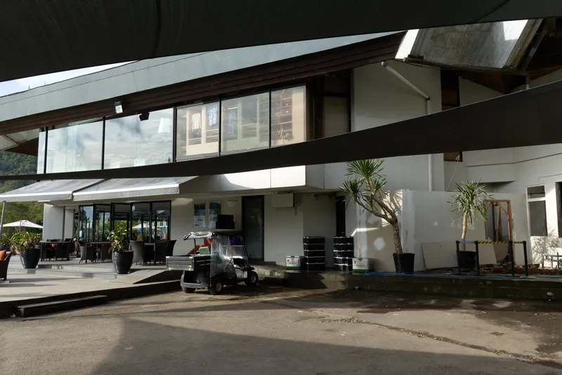 Modern architectural design of a restaurant with outdoor seating and a tropical atmosphere, highlighting sleek lines and natural elements, perfect for summer dining