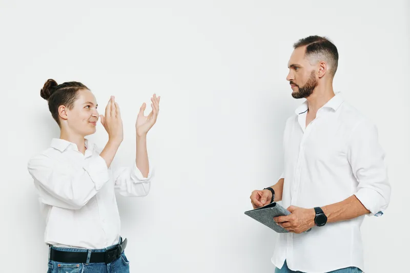 A professional businessman stands on an isolated colored background, projecting confident emotion while engaging with a colleague. Clean, modern scene highlighting achievement, leadership, and