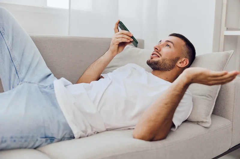 A man expressing vulnerability during an emotional phone call, showcasing the impact of soft masculinity and therapy culture in daily life.