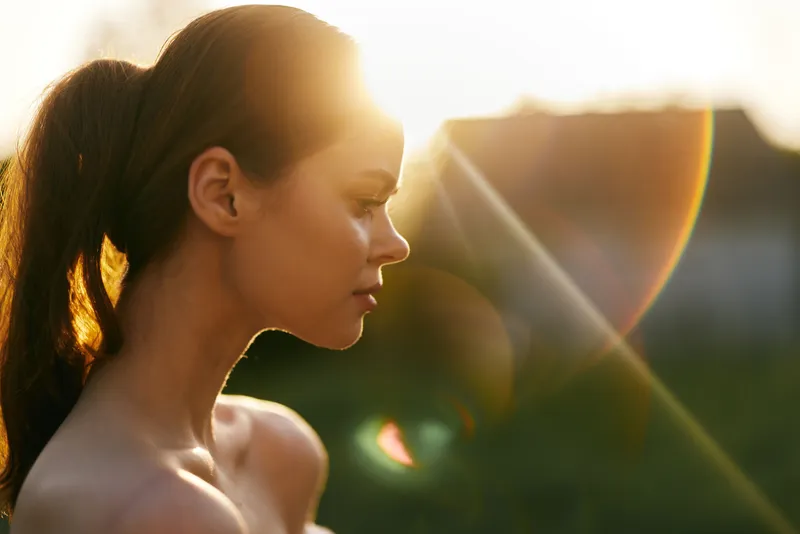 Young woman in natural light at sunset, showcasing serene emotion and minimalistic style with soft background Lifestyle photography