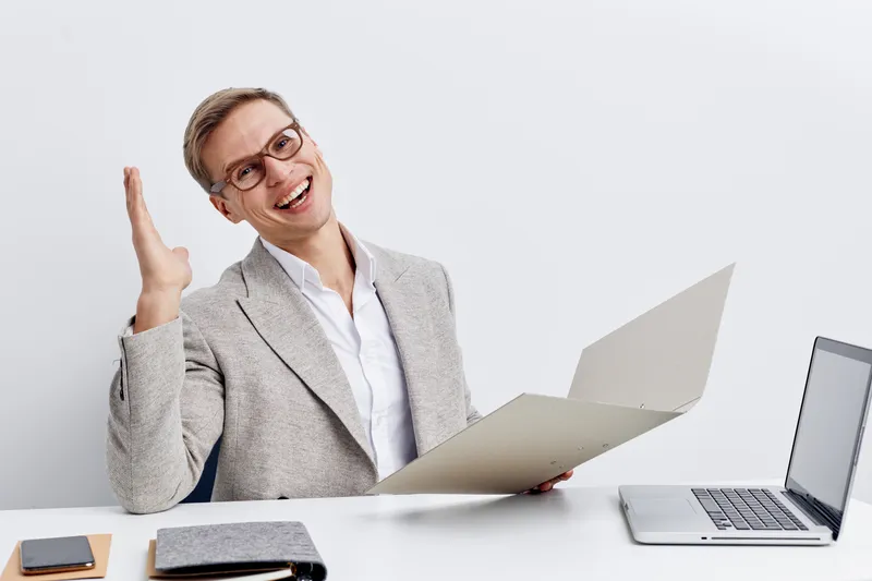 Happy young caucasian man working with laptop and smartphone in modern office digital nomad lifestyle concept