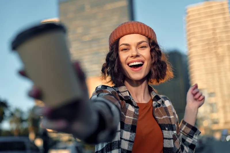woman coffee smile city portrait candid urban happiness captured in golden hour glow, authenticity and candid lifestyle vibe, joyful emotional storytelling and mindful living in modern street energy.