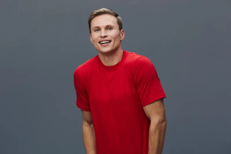 smiling young man wear red t-shirt look camera happy casual caucasian male studio portrait mental health and gadgets concept