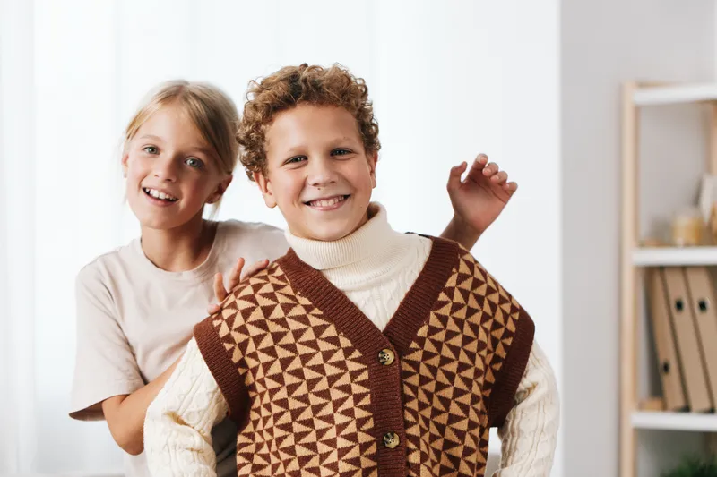 Authentic scene of two children indoors, engaged in a playful moment at home, highlighting school life and genuine interaction through a candid lifestyle depiction.