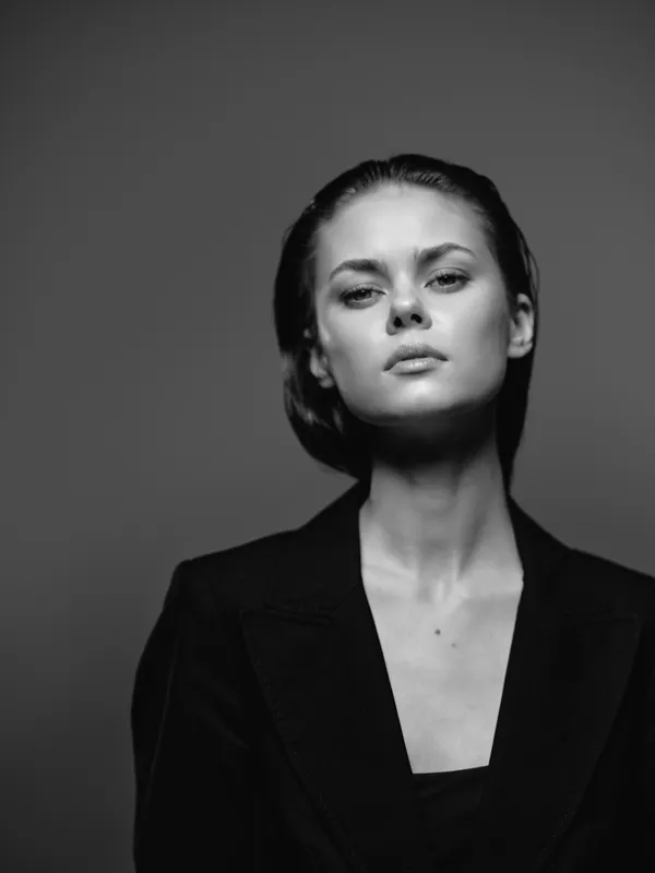 Black and white portrait of a serious woman in a blazer with short hair and a neutral expression