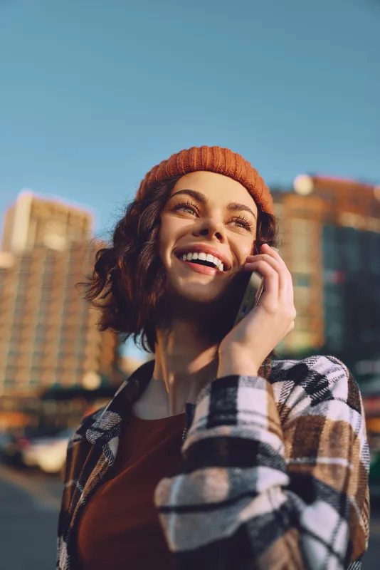 Woman on phone smile in urban street at golden hour, candid authenticity and emotional storytelling vibe, mindful living portrait with warm glow and modern city lifestyle.