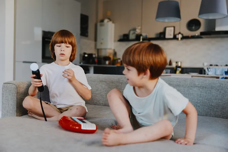 Playful boys engaged in creative activities indoors, showcasing their joy and imagination through playtime with toys in a cozy setting.