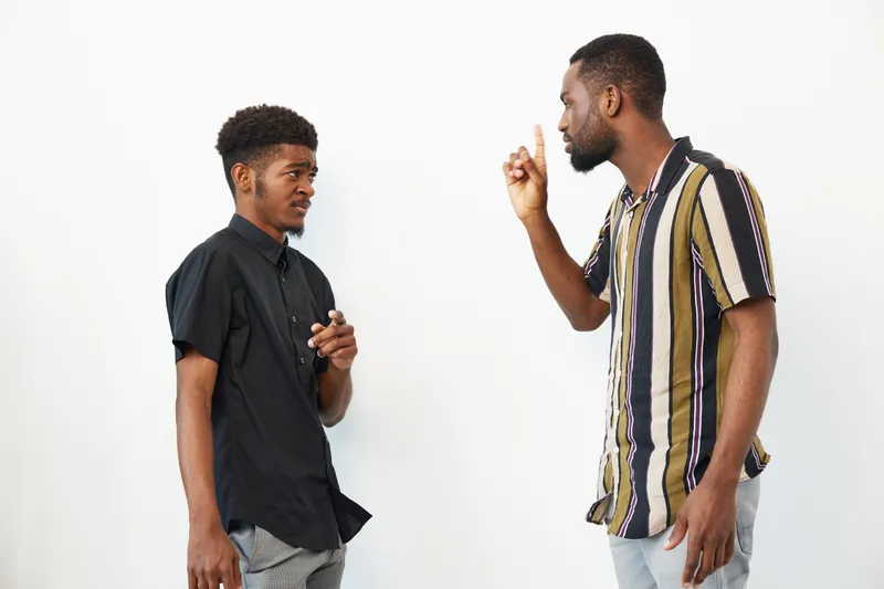 Engaged African American men discussing ideas passionately, showcasing strong emotions and expressive gestures in a modern setting.