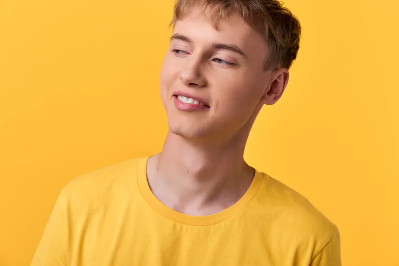 Smiling man wearing a yellow shirt against a yellow background, casual style and upbeat mood, a friendly approachable look suitable for lifestyle and fashion campaigns with a clean studio photo feel