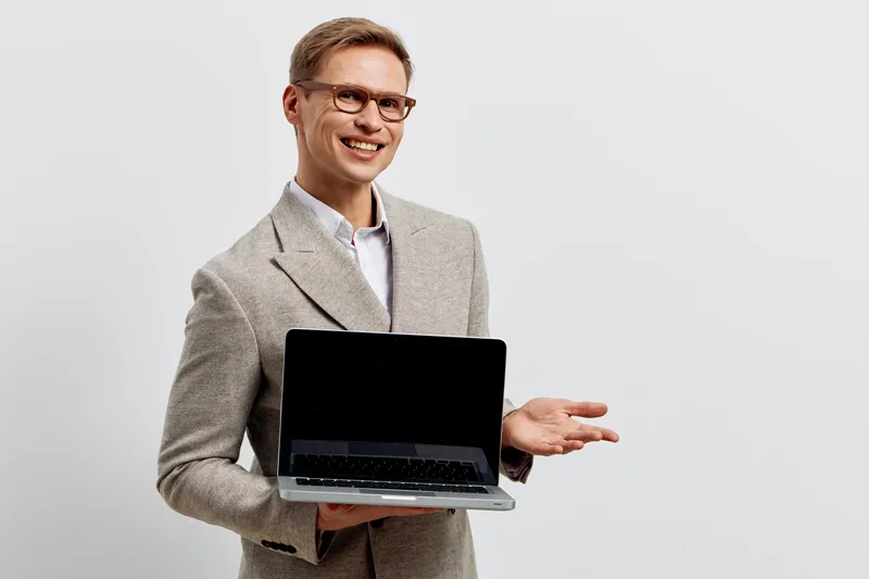Confident smiling man in formal blazer holding open laptop computer tackle business presentation isolated on plain white background studio portrait. People lifestyle concept