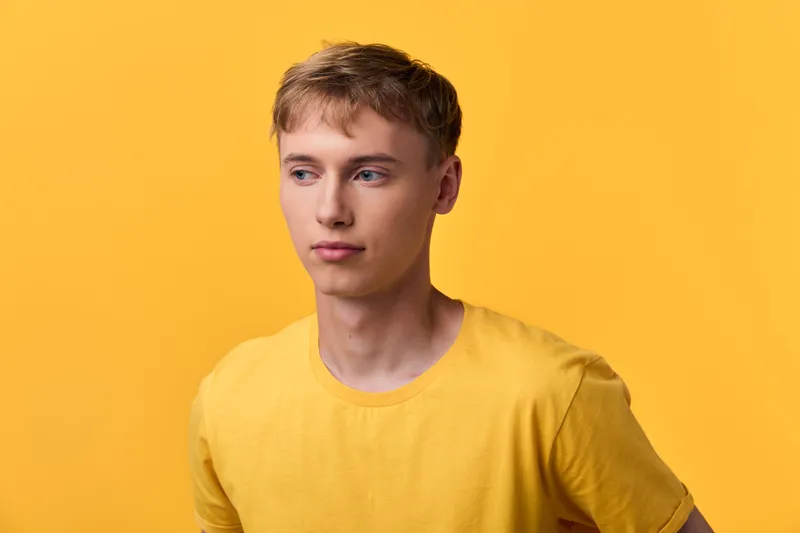 Young man yellow shirt yellow background casual composition featuring a neutral expression and relaxed posture for fashion lifestyle and stock photography