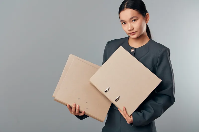 Woman holding two cardboard boxes for shipping and delivery on gray background. Female with parcel, mail, package, logistics and e commerce concept for online order and transportation.