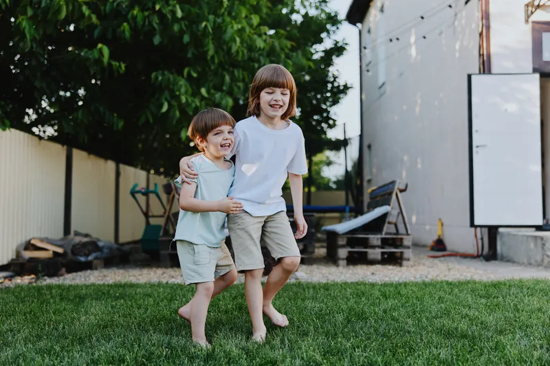 Happy children playing outdoors in a garden, enjoying the warm sunshine and a playful atmosphere. Their laughter fills the air as they bond and create memories.