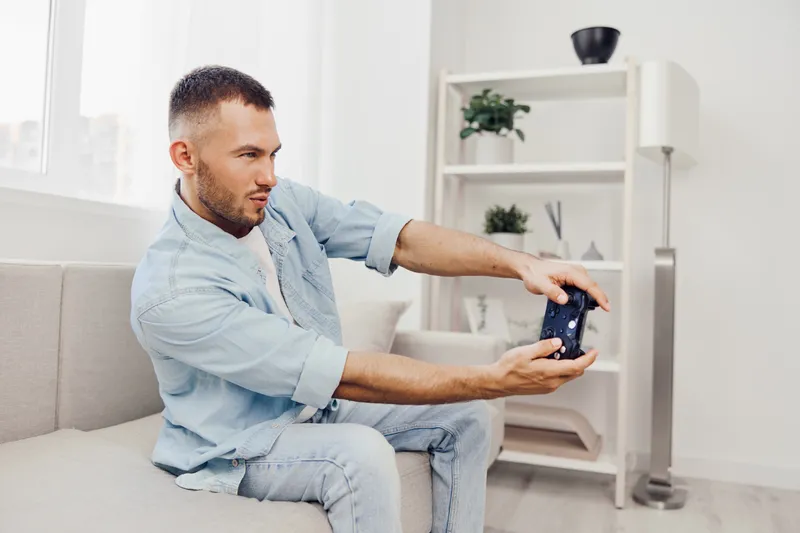 A focused man engaging with his smartphone during a digital detox, conveying themes of AI anxiety and emotional minimalism in a cozy home setting.
