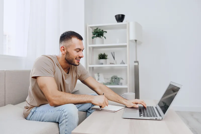 Relaxed man working on a laptop at home, showcasing remote work vibes and modern living. Ideal for themes of productivity and comfort in 2025 and beyond.