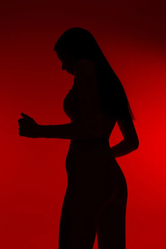Silhouette of a woman sport fitness athlete jogging, showcasing strength and endurance with a vibrant red background highlighting movement and energy.