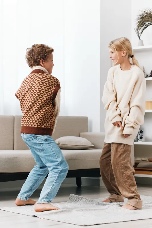 Authenticity and play define this scene, where children enjoy indoor activity and casual lifestyle, blending school energy with warm home vibes and candid moments.