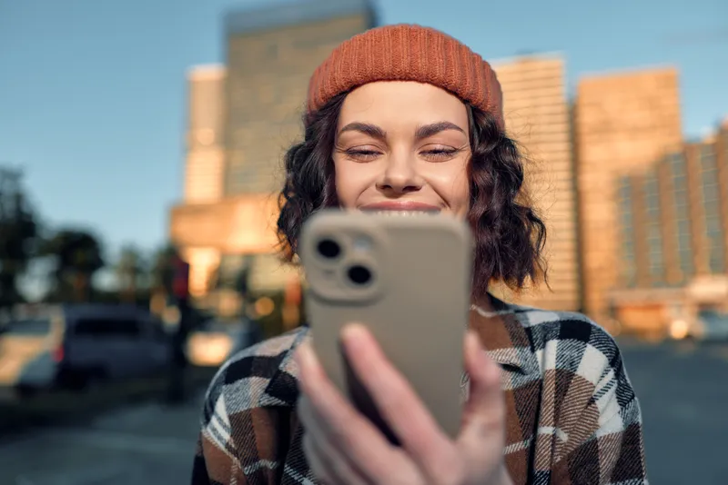 woman smartphone smile city golden candid portrait of a young urban woman smiling at her phone in golden hour glow, authenticity and mindful living captured in emotional storytelling