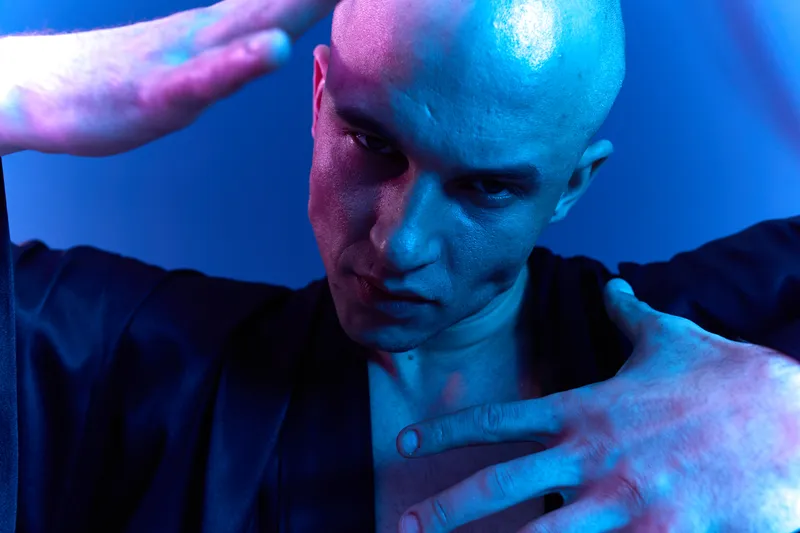 Intense man expression in black and white, showcasing emotion through a dramatic pose and unique lighting effects, conveying depth and creativity.