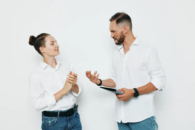 Professional businessman on an isolated colored background, showing confident emotion while interacting with a colleague, conveying leadership, collaboration, and clear communication.