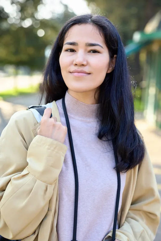 Woman wearing casual jacket with backpack standing outdoors, natural light, relaxed mood, lifestyle fashion and travel style for everyday moments and comfort