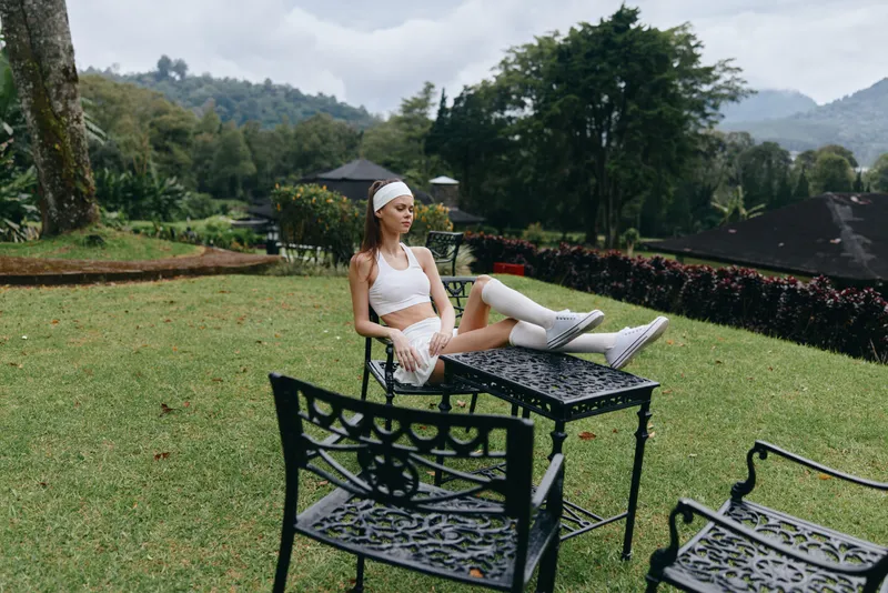 Young woman practicing yoga outdoors in sportswear, expressing calmness and focus while enjoying nature and fresh air on a beautiful sunny day