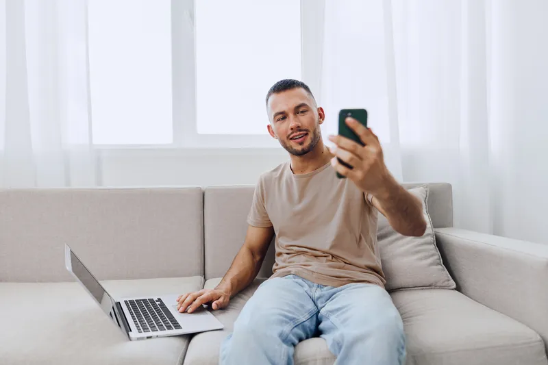 Smiling man engaging in honest phone call, showcasing mental health awareness and emotional connection amidst modern challenges like work-life blur and AI anxiety.