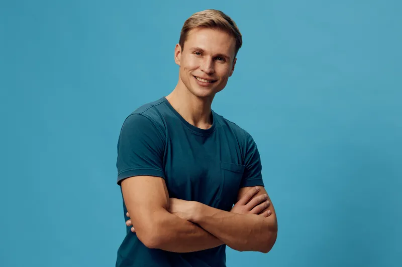 smiling caucasian man folded arms stand blue background casual t-shirt confident young adult digital nomad lifestyle concept