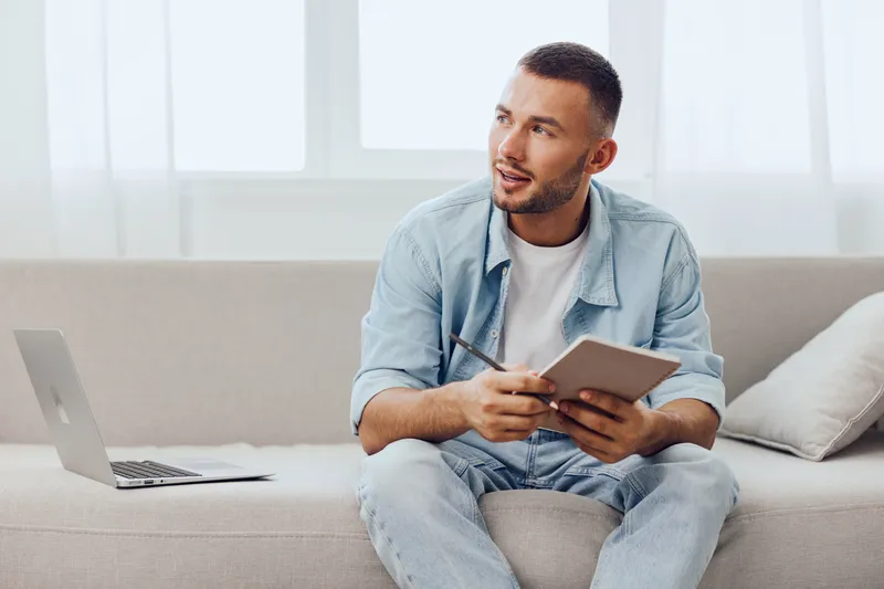 Thoughtful man engaged in creative reflection, balancing work and personal life, embracing emotional well-being and mental health amidst a digital landscape.