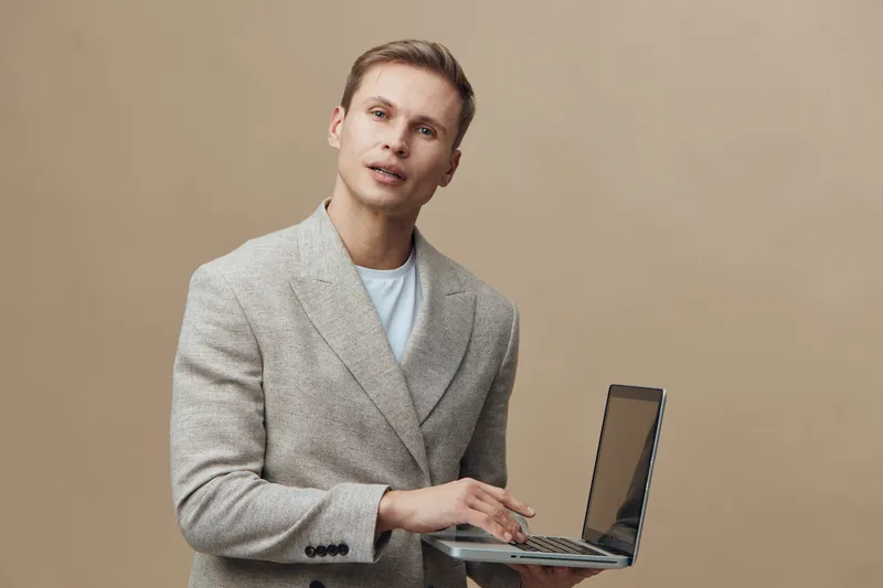 Young handsome caucasian man smart casual wear hold laptop work on digital nomad concept beige background