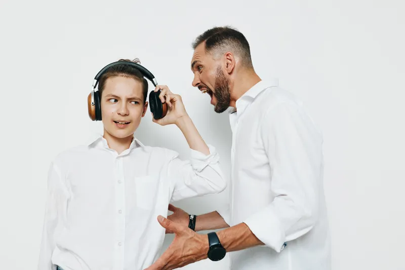 A business professional man engages with a younger colleague against an isolated colored background, showing intense emotion, energy, and dynamic interaction perfect for corporate training and