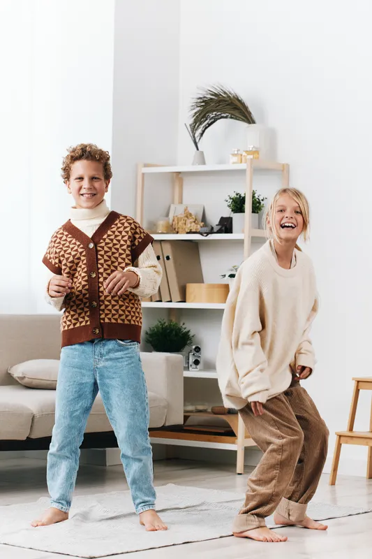 Authenticity play scene with children dancing indoors, home setting, cozy outfits, candid movement, bright mood, lifestyle focus, school inspired charm.