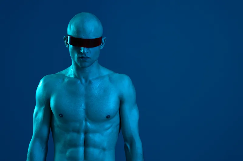 Striking blue image of a man with a futuristic look, wearing sunglasses. The subject's skin has a unique tone, enhancing the visual appeal. Concept: modern style.