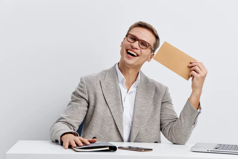 cheerful caucasian man working digital nomad hold envelope smile in office casual jacket white background