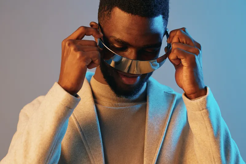 Stylish Black Male Model Wearing Sunglasses in a Trendy Setting, Expressing Confidence and Style