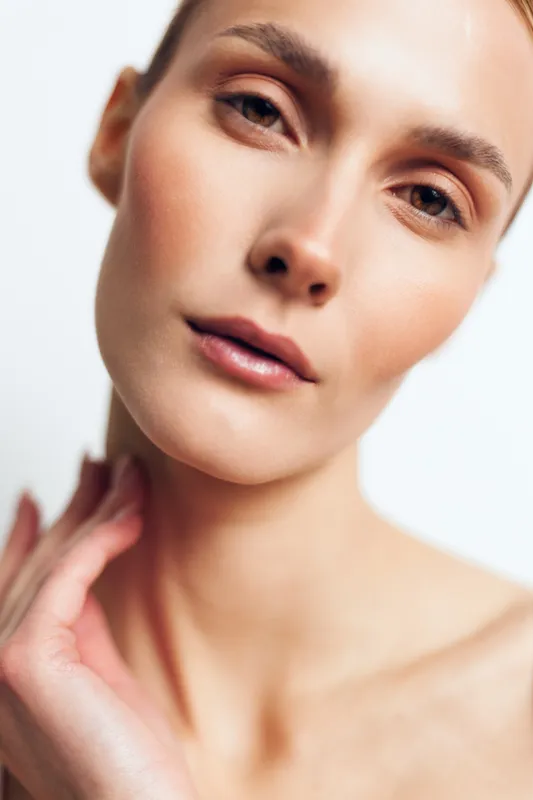 Woman, skincare, close up, face, wellness, self care, applying cream, soft studio light, calm expression, natural skin texture, beauty routine, white background