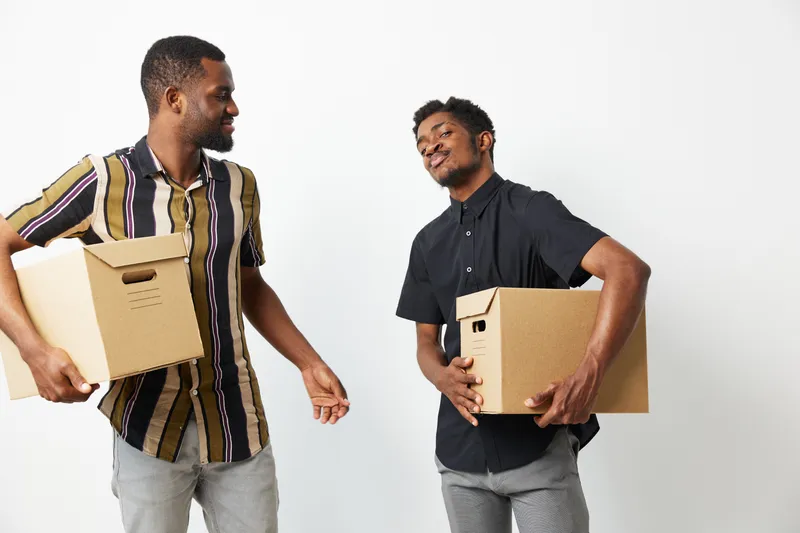 Friendly African American men holding cardboard boxes, showcasing teamwork and collaboration in a modern workspace environment. Bright and engaging vibe. ???????? 2: