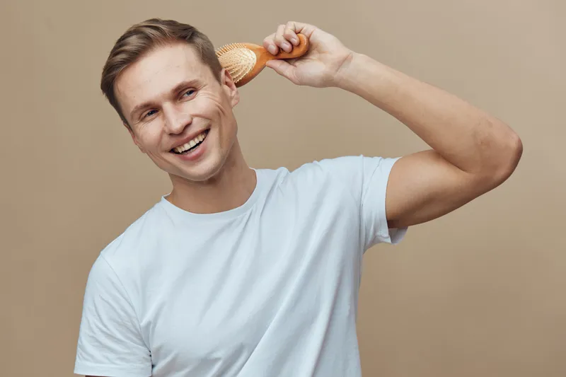 Smiling man with seashell on ear wear white t-shirt isolated on beige background cheerful happy look technology digital detox concept