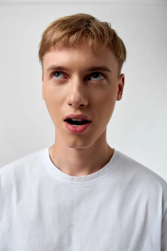surprised expression man astonishment white shirt looking upward curious emotion facial youth reaction astonished gaze casual studio wonder disbelief awareness alert surprised look photogenic head