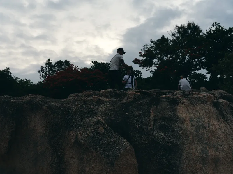 Photographers capturing landscapes in a serene outdoor setting with dramatic clouds and vibrant foliage Emotion of inspiration and creativity is evident