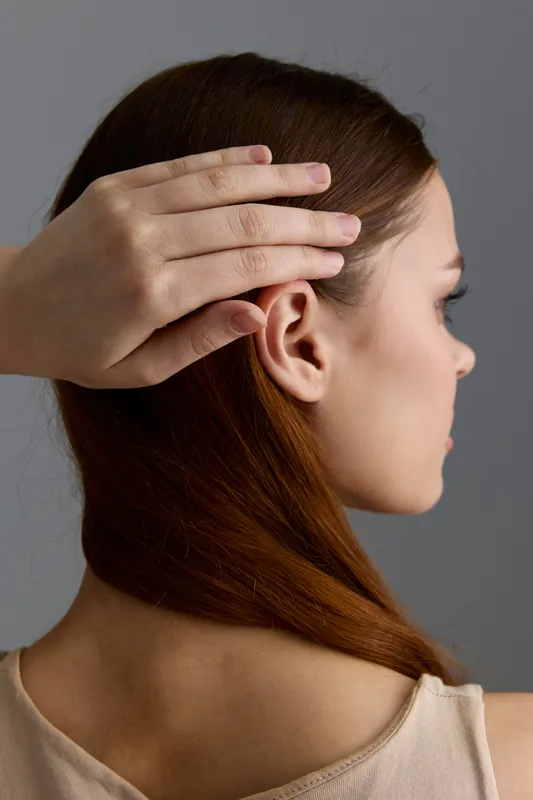 beauty woman with red hair gently touching head, natural skin, side profile, soft lighting, minimalistic background, calm and serene mood