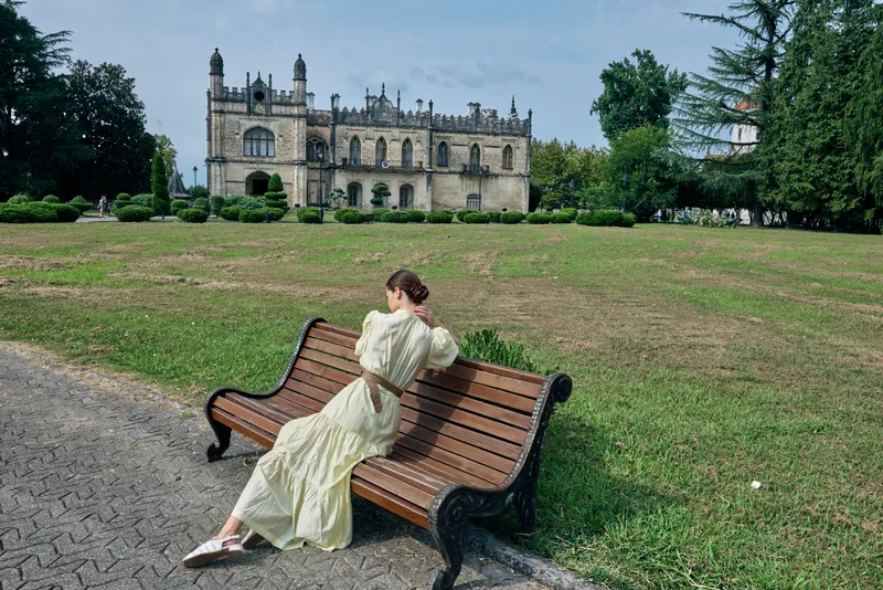 woman bench historic building park dress solitude authenticity inclusivity, woman in light dress seated outdoors