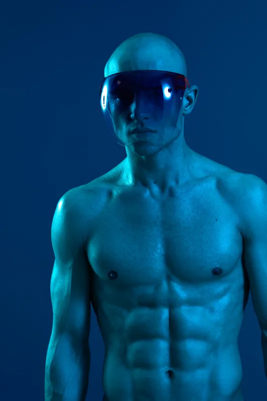 Athletic man posing in stylish futuristic eyewear, showcasing a bold blue color scheme and powerful expressions. A striking visual representation of modern fashion.