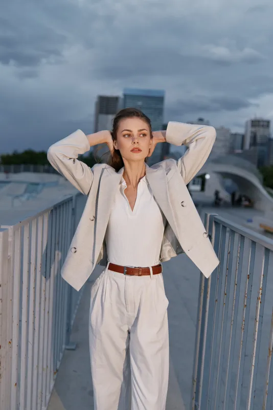 Confident businesswoman posing outdoors in stylish attire with a modern city background, showcasing professionalism and elegance in the corporate world.
