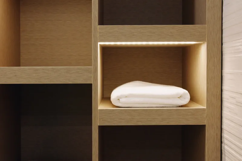 Shelf with a folded towel, wooden storage cubby, minimalist interior and neat organization showcasing clean furniture design in a calm home space