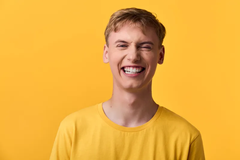 Smiling man in a yellow shirt against a bright yellow background, conveying happiness, positivity, and friendly energy for lifestyle and upbeat branding visuals and campaigns.
