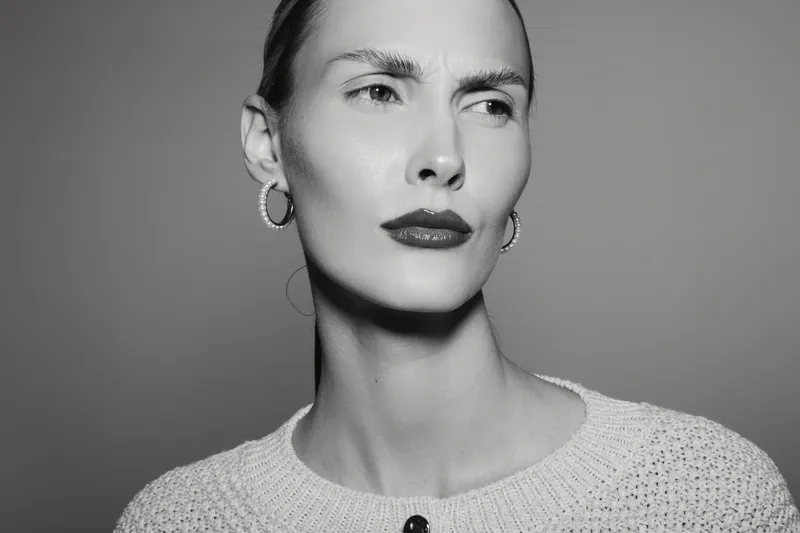 Serious Caucasian woman with fair skin and short hair looks away in black and white portrait. Concept for emotion, contemplation, and fashion.
