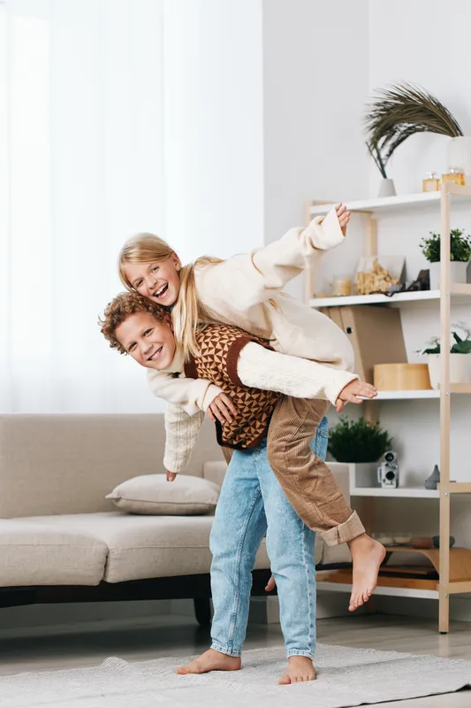 Authenticity shines in a playful home scene featuring a piggyback moment, a cozy lifestyle moment rooted in play, family warmth, and school age energy.