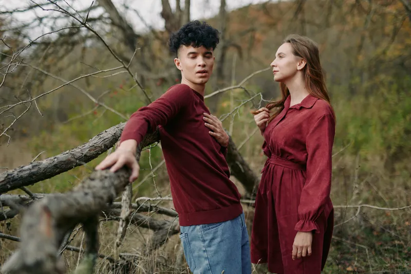 Close candid portrait of a young couple in a woodland clearing, showing authentic interaction and subtle body language, gentle expressions and relaxed posture captured in natural light to convey