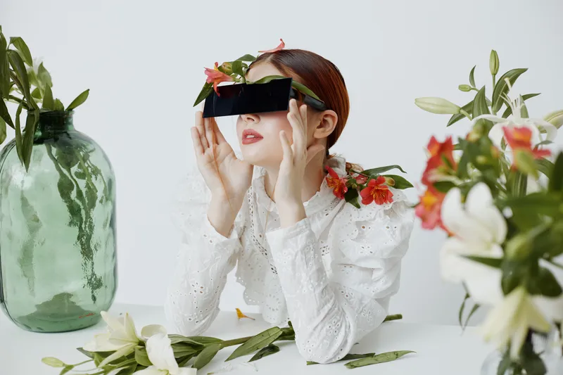 Stylish woman with flowers and sunglasses against a soft background, expressing calm emotions in a spring inspired concept